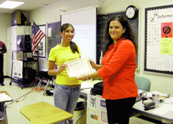 Justine Fradillada, an Olympic Heights High School student, receives a certificate from Jessica Stokes, education and research coordinator from Debt Management Credit Counseling Corp., for successful completion of the Financial Literacy program.  